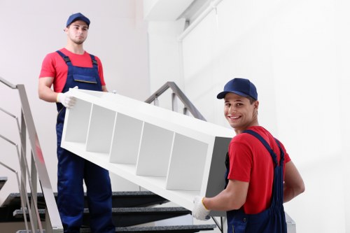 Removal team handling furniture safely with protective equipment